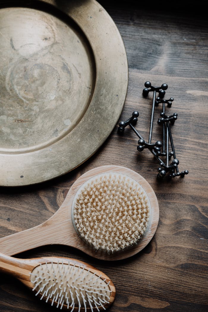 Home A flat lay of wooden brushes and metal items on a rustic wooden table surface.