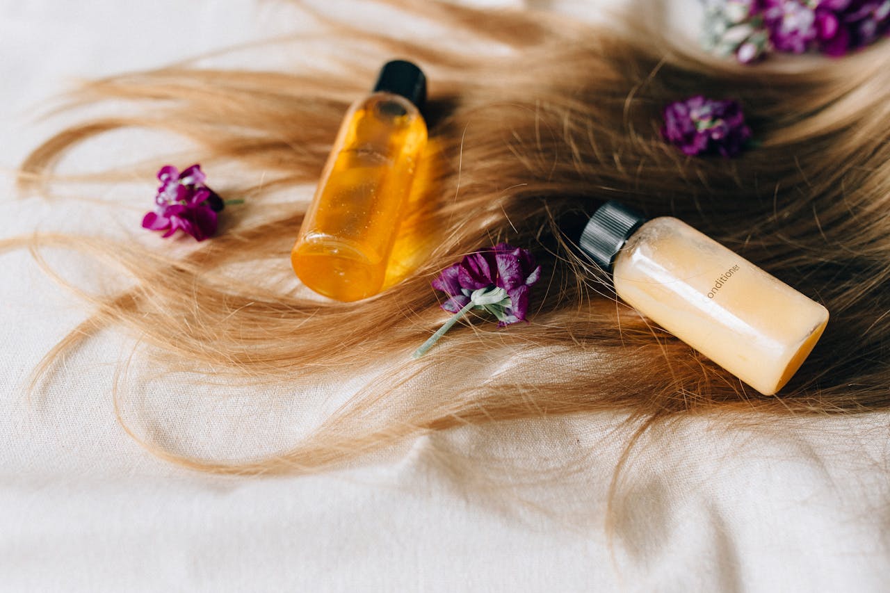 Home Hair care products on a bed of hair and flowers, symbolizing luxury and beauty.